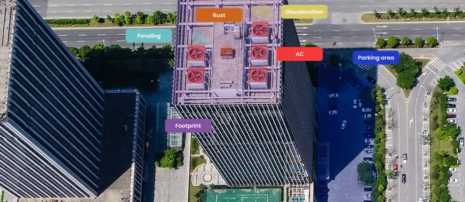 Aerial view of a high-rise with rooftop equipment and parking tagged